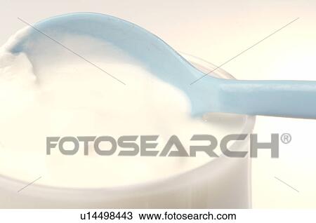 Stock Image - Yoghurt in a glass and a spoon. Fotosearch