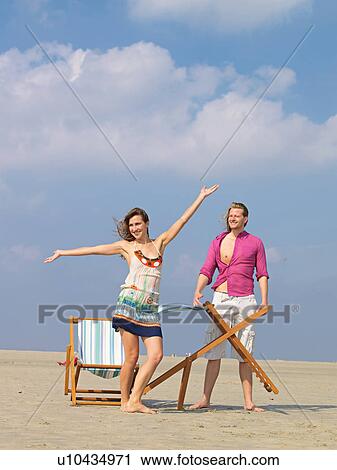 Stock Image - Young couple and canvas chair. Fotosearch