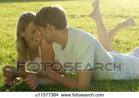 Picture - Young couple lying on lawn. Fotosearch