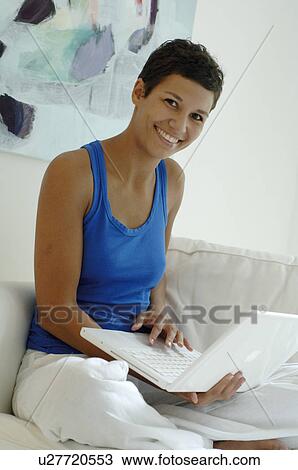 Stock Image - Young lady with laptop. Fotosearch