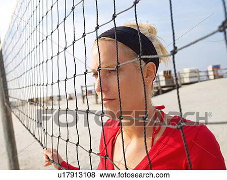 Stock Photo - Young woman at the beachball net. Fotosearch