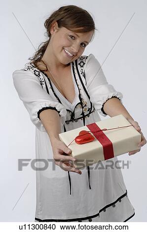 Young woman handing over gift View Large Photo Image Stock Image - Young woman handing over gift. Fotosearch