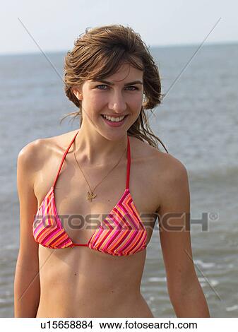 Picture - Young woman with armbands on the beach. Fotosearch