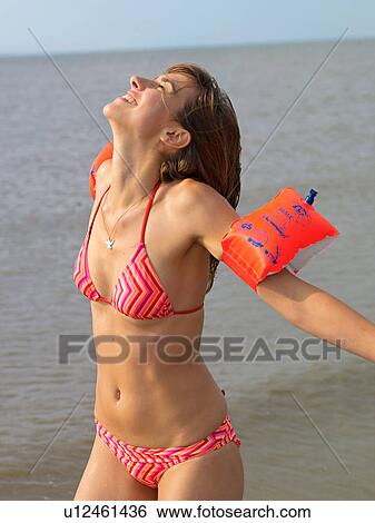 Young woman with armbands on the beach View Large Photo Image Stock Photograph - Young woman with armbands on the beach. Fotosearch