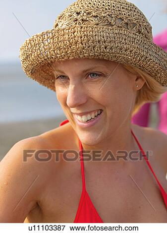 Stock Photo - Young woman with hat on the beach. Fotosearch