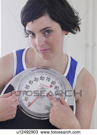 Stock Image - young woman with scales. Fotosearch