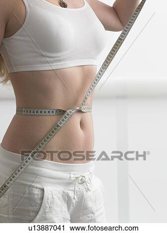A measuring tape is twined around a woman' s belly View Large Photo Image Stock Image - A measuring tape is twined around a woman' s belly. Fotosearch