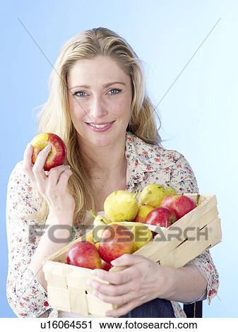 Stock Image - Blonde woman with a fruit basket. Fotosearch