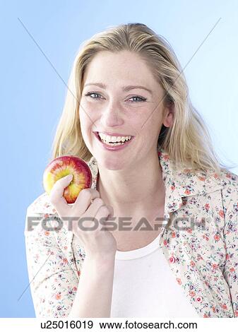 Stock Photo - Blonde woman with an apple. Fotosearch