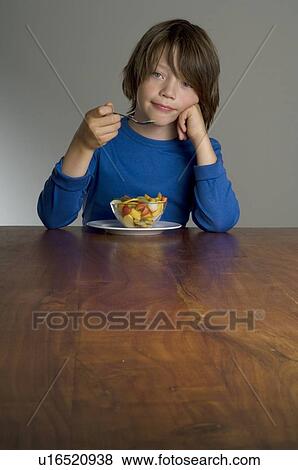 Boy eating fruit salad View Large Photo Image Stock Photo - Boy eating fruit salad. Fotosearch