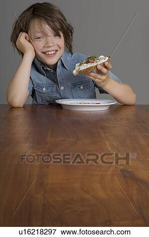 Stock Photo - Boy eating open-faced sandwich. Fotosearch