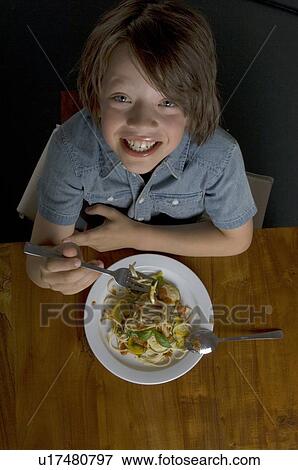 Stock Photo - Boy eating pasta with vegetables. Fotosearch