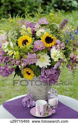 Stock Photography - Bunch of flowers in a vase on a garden table. Fotosearch