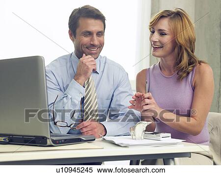 Business couple at the computer View Large Photo Image Stock Photography - Business couple at the computer. Fotosearch