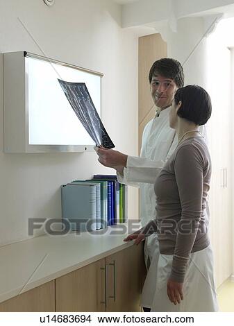Picture - Doctor discussing an x-ray photograph with his patient. Fotosearch