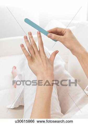 Stock Photograph - Filing finger nails. Fotosearch