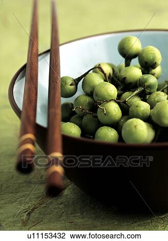 Stock Image - Green berries in bowl with chopsticks. Fotosearch