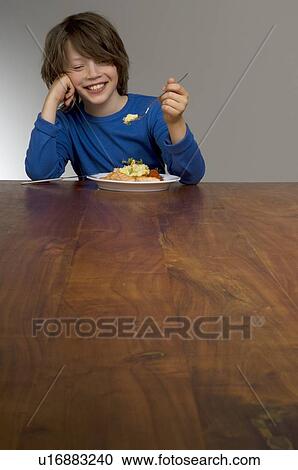 Happy boy eating lunch View Large Photo Image Stock Image - Happy boy eating lunch. Fotosearch