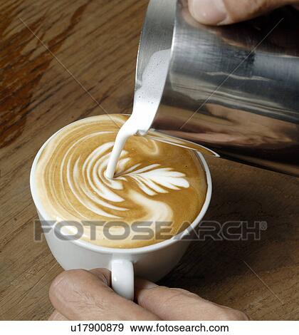 Stock Photo - Pouring milk into a cup of coffee. Fotosearch