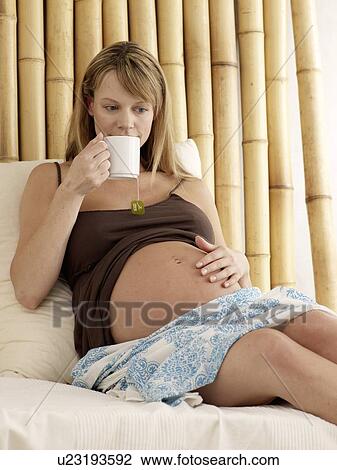 Pregnant woman drinks a cup of coffee View Large Photo Image Stock Image - Pregnant woman drinks a cup of coffee. Fotosearch