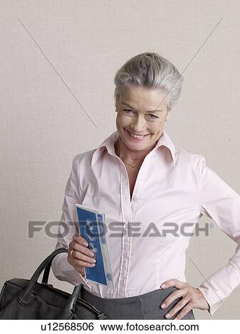 Stock Photograph - Senior citizen in business wear with ticket and carpetbag. Fotosearch