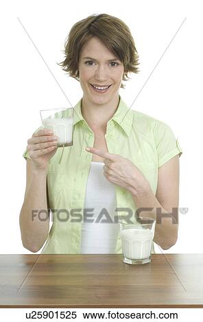Smiling woman holding glass of milk View Large Photo Image Stock Photography - Smiling woman holding glass of milk. Fotosearch