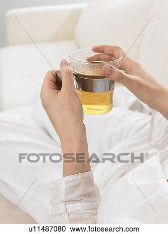 Stock Image - Tea glass held by two hands. Fotosearch