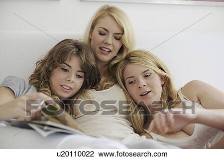 Three sisters reading magazines in bed View Large Photo Image Stock Image - Three sisters reading magazines in bed. Fotosearch