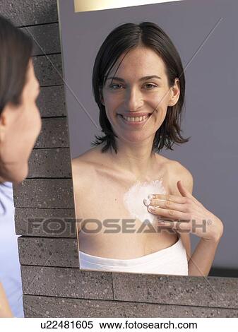 Woman applies lotion to her decollete View Large Photo Image Stock Photography - Woman applies lotion to her decollete. Fotosearch