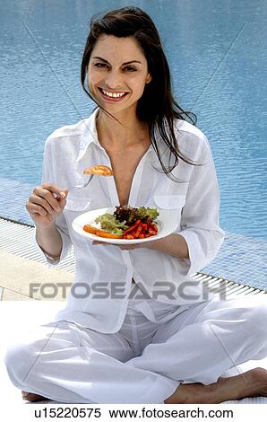 Woman dressed in white eating salad at the swimming pool View Large Photo Image Stock Photography - Woman dressed in white eating salad at the swimming pool. Fotosearch