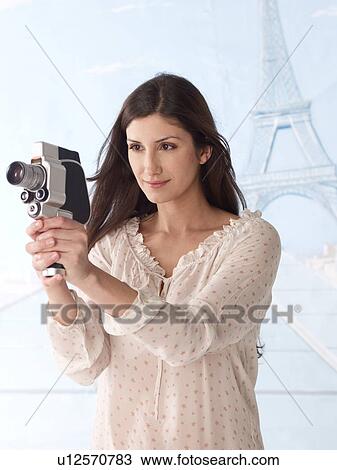 Stock Image - Woman filming with Eiffel Tower in background. Fotosearch