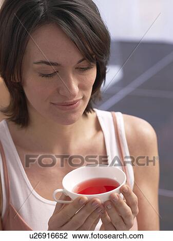 Stock Image - Woman holding a cup of tea. Fotosearch