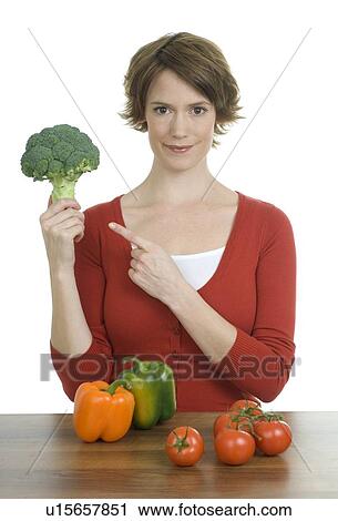 Woman holding up broccoli View Large Photo Image Stock Image - Woman holding up broccoli. Fotosearch
