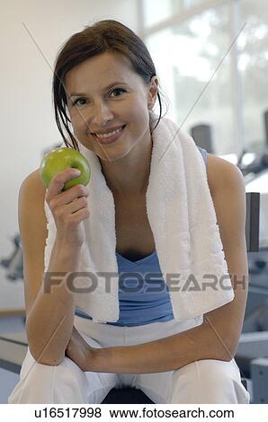 Woman in the gym eating an apple View Large Photo Image Stock Photo - Woman in the gym eating an apple. Fotosearch