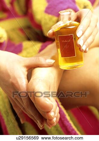 Woman oiling her foot with poppy oil (close-up) View Large Photo Image Stock Photo - Woman oiling her foot with poppy oil (close-up). Fotosearch