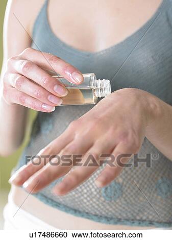 Stock Image - Woman oiling her hand (close-up). Fotosearch