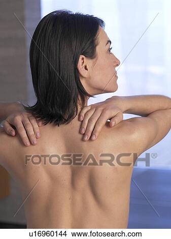 Picture - Woman sitting on massage table, backview. Fotosearch