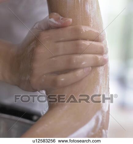 Stock Photograph - Woman washing her arm with water (close-up). Fotosearch