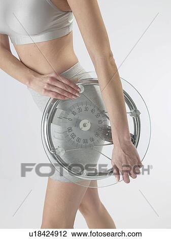 Woman with a bathroom scale View Large Photo Image Stock Image - Woman with a bathroom scale. Fotosearch