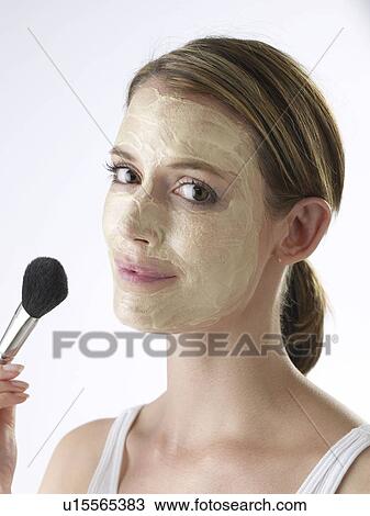 Stock Image - Woman with a facial mask. Fotosearch