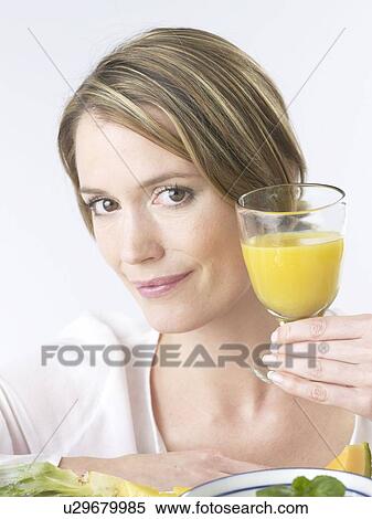 Woman with a glass of orange juice View Large Photo Image Stock Photography - Woman with a glass of orange juice. Fotosearch