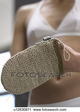 Stock Image - Woman with massage glove made of sisal (close-up). Fotosearch