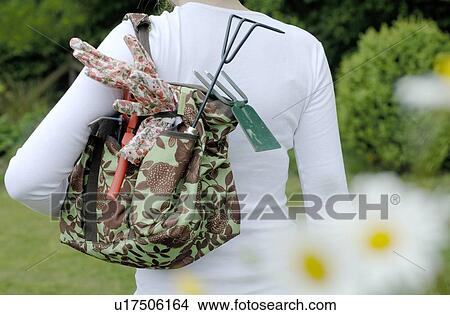 Picture - Young Woman carrying gardening tools in a bag. Fotosearch