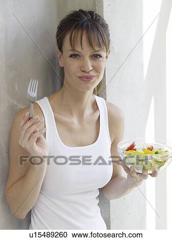 Young woman eating salad View Large Photo Image Stock Image - Young woman eating salad. Fotosearch
