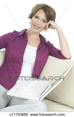 Young woman in casual wear with laptop sitting on sofa View Large Photo Image Stock Image - Young woman in casual wear with laptop sitting on sofa. Fotosearch