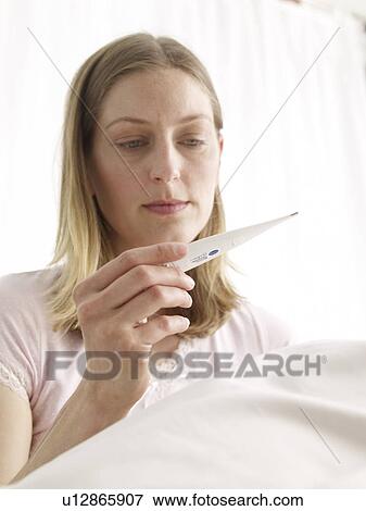 Stock Photo - young woman with clinical thermometer. Fotosearch