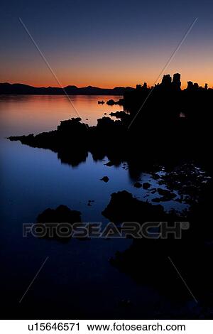 Blue and orange dawn light silhouettes the tufa formations of Mono Lake on a calm summer morning, with deep reflections in the still water View Large Photo Image Stock Image - Blue and orange dawn light silhouettes the tufa formations of Mono Lake on a calm summer morning, with deep reflections in the still water. Fotosearch