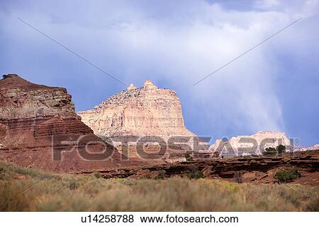 Butte formations and sage brush foreground against stormy blue sky with rain clouds, Reds Canyon, Utah View Large Photo Image Stock Photo - Butte formations and sage brush foreground against stormy blue sky with rain clouds, Reds Canyon, Utah. Fotosearch