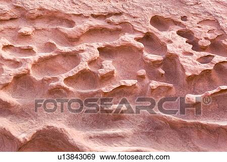 Stock Photo - Close up detail of pockmarked red rock face - effect of water flow flooding canyon, Reds Canyon, Utah. Fotosearch
