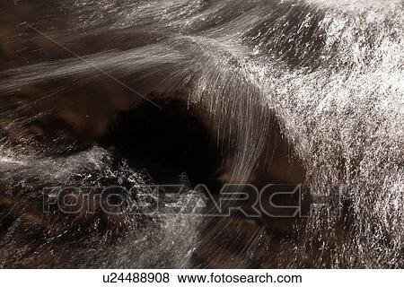 Stock Photo - Desaturated image of river flowing over rocks, motion slowed to capture linear highlights, and texture of water, Utah. Fotosearch
